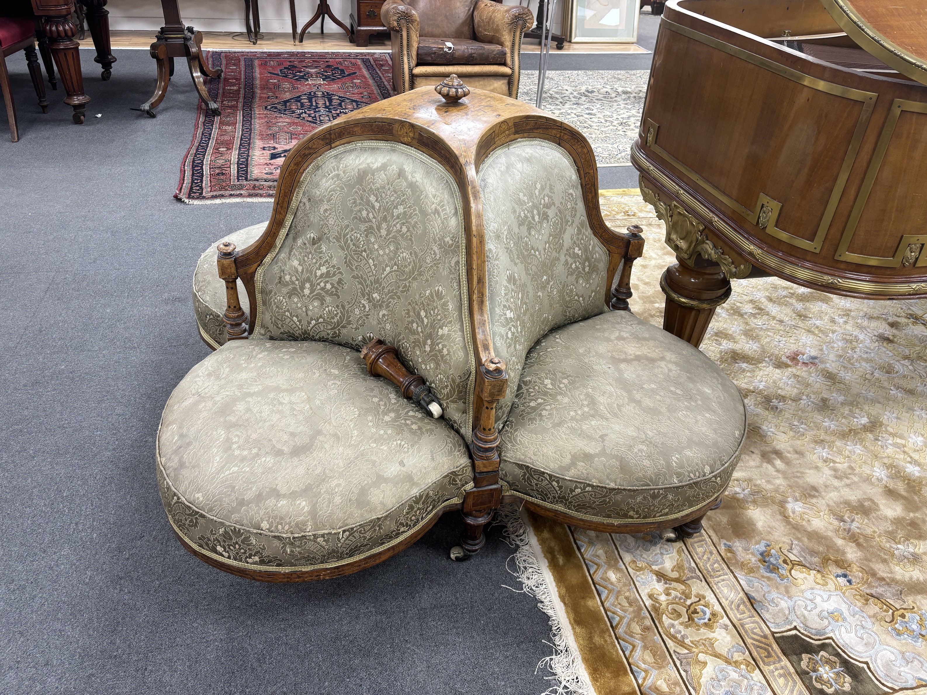 A late Victorian amboyna banded walnut conversation seat, (one leg detached), width 140cm, height 86cm
